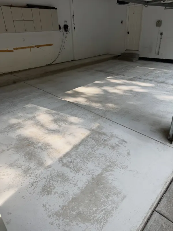 Garage floor before, uneven and worn concrete with patchy color