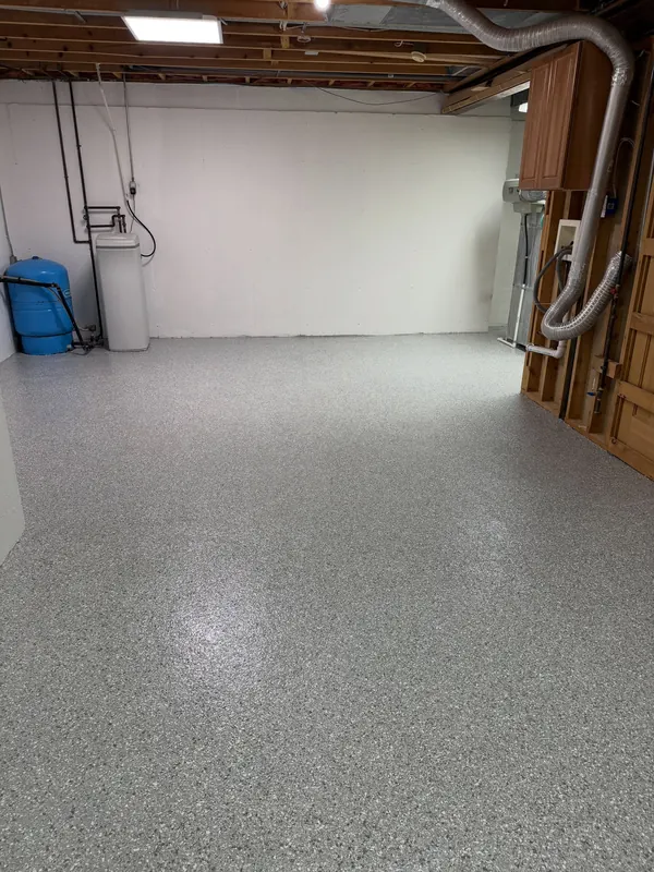 White-walled utility room with a water softener and a bright flake floor