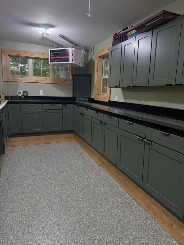 Light flake floor coating running along green cabinets and a black countertop