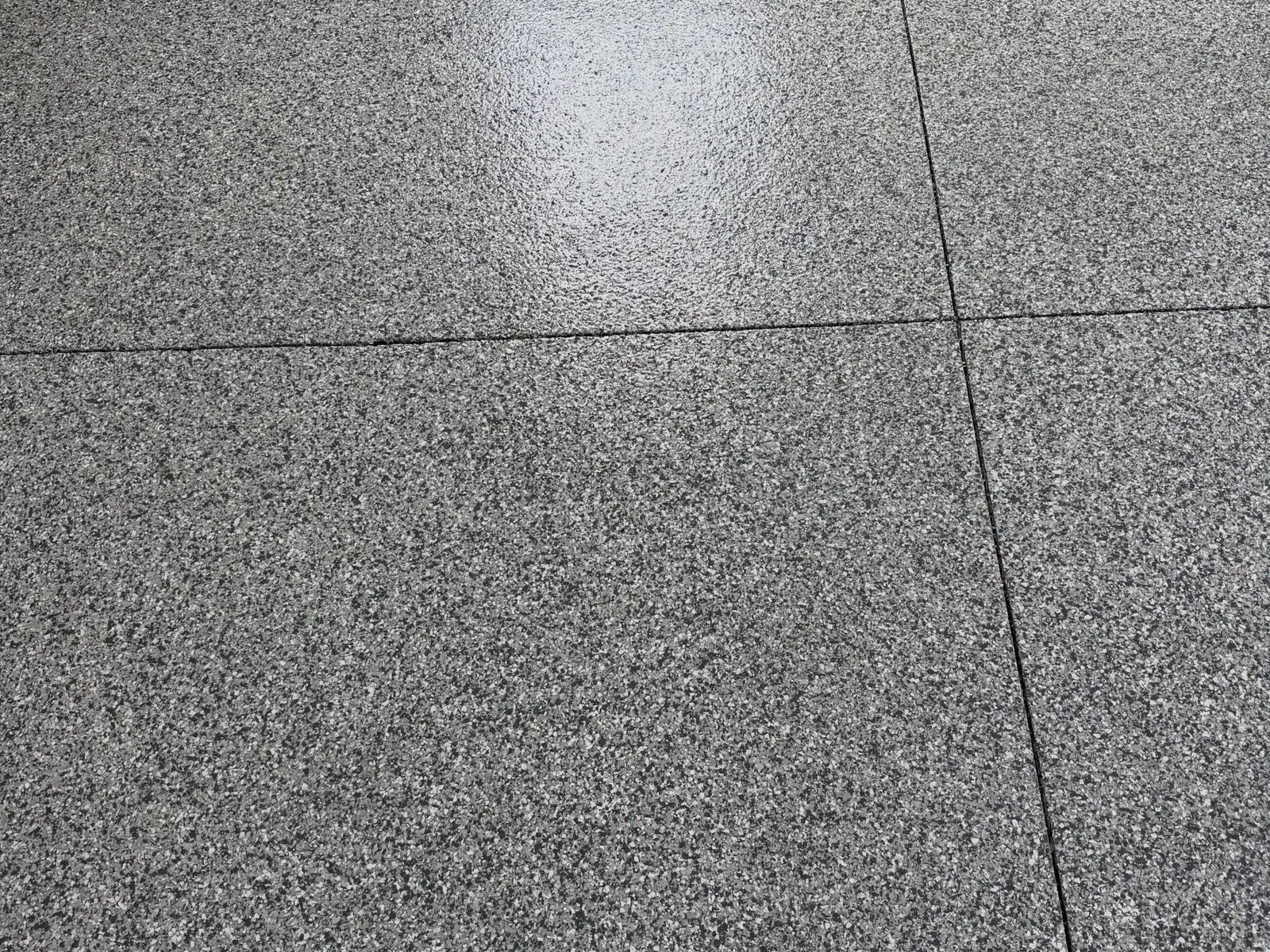 Close look at a finished full-flake floor with gray, white and black chips under a glossy topcoat