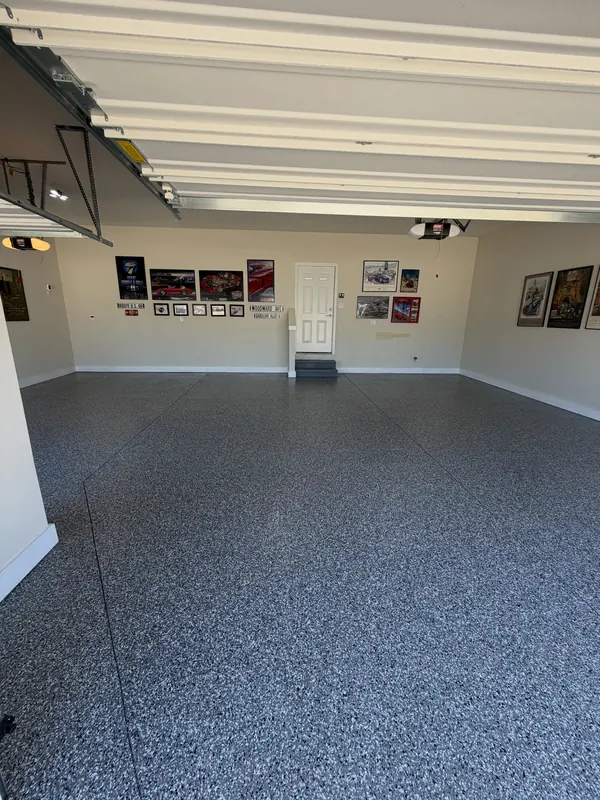 Large garage with a gray flake floor and framed prints along the walls