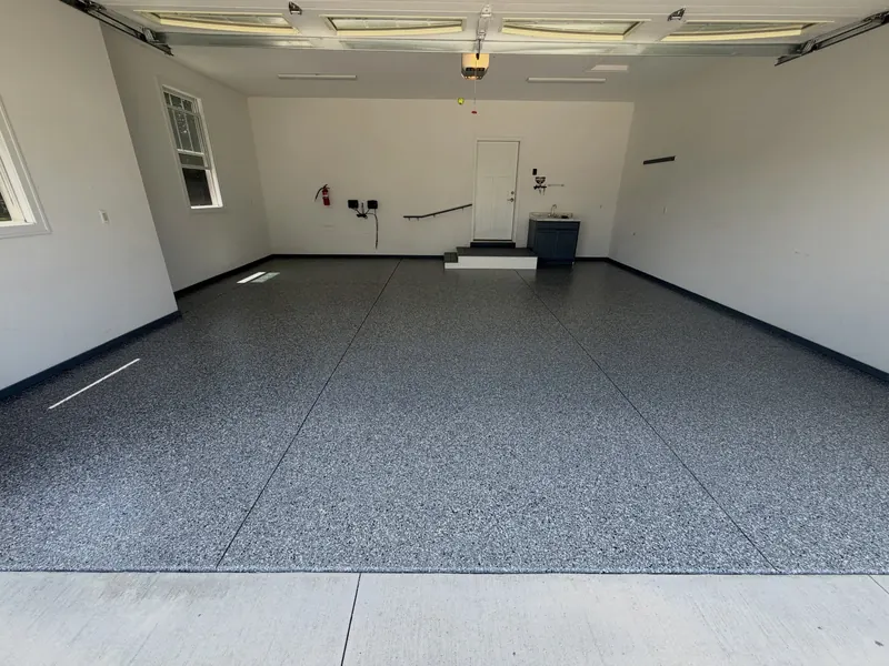 Two-car garage with a gray full-flake floor and bright white walls