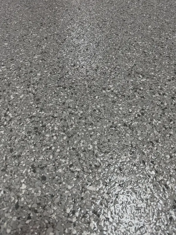 Close-up of an even gray flake broadcast under a smooth, glossy topcoat