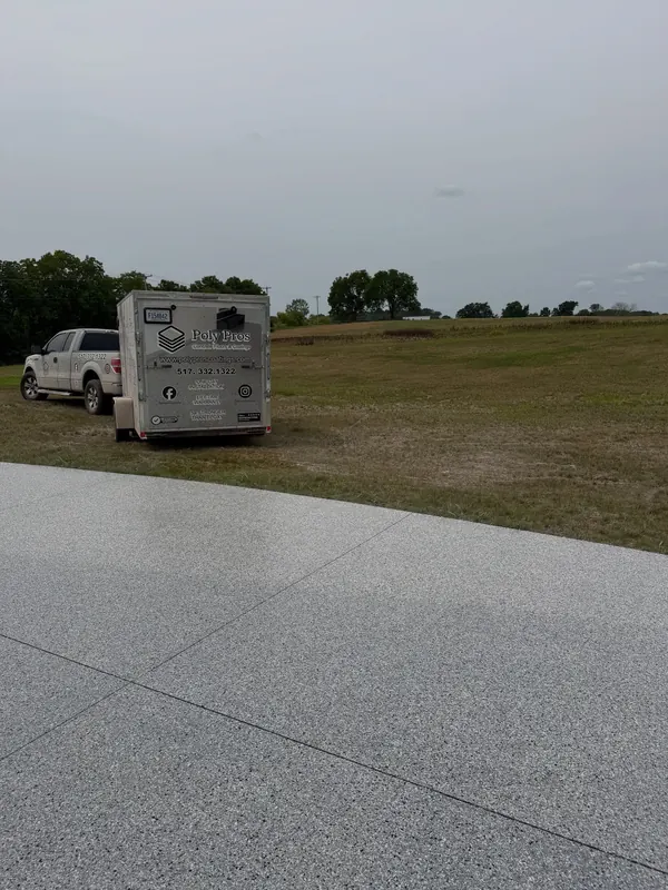 Large coated outdoor slab with a work truck and trailer parked beyond it
