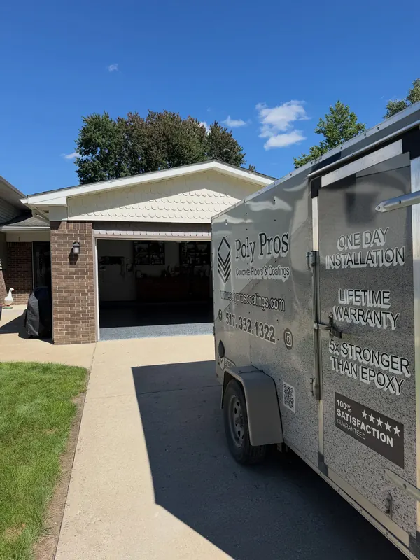 Poly Pro's Coatings trailer parked in a customer's driveway during a garage floor job